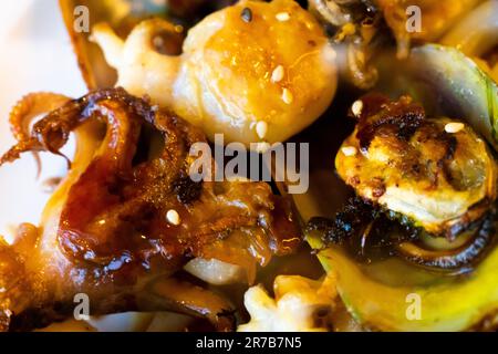 Gegrilltes galizisches Oktopusbein mit Sauce auf dem Teller im Restaurant aus nächster Nähe Stockfoto