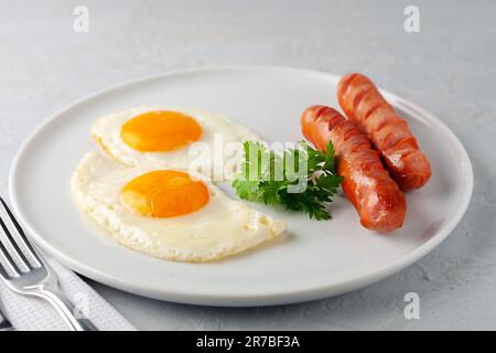Rührei mit gegrillten Würstchen und Petersilie Stockfoto