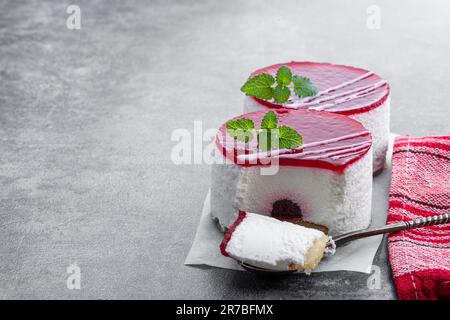 Mini-Käsekuchen mit roter Obstmarmelade auf grauem Hintergrund Stockfoto