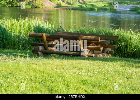 Moderner Loungebereich. Holzbänke, Tische. Campingplatz. Sommer. Idyllische Landschaft. Ökotourismus ein schöner Urlaub. Stockfoto