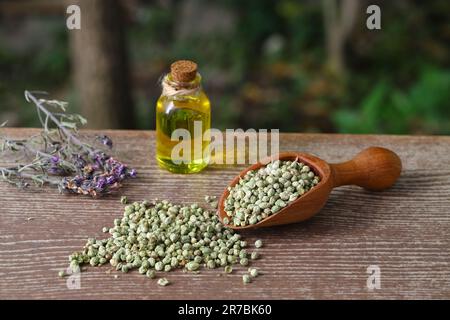 Thymian ätherisches Öl und Heap von trockenem Thymian in Holzlöffel und in Schüssel auf Holzgrund. Getrocknete Gewürz zahter Thymian und Öl Konzept Stockfoto