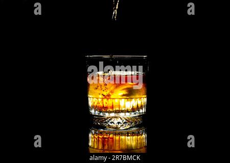 Glasbecher mit Whiskey auf schwarzem Hintergrund Stockfoto