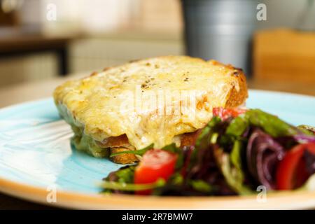 Klassischer französischer Toast mit Käse und Schinken, Gemüse und Honigbalsam-Dressing. Stockfoto