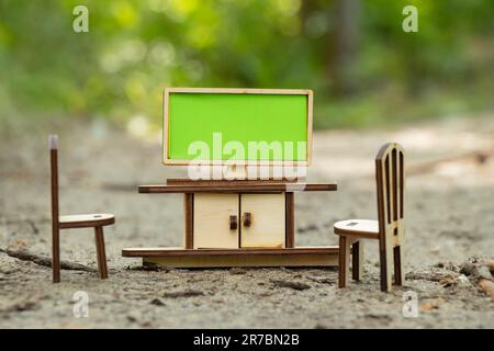 TV-Tisch und -Stuhl in Miniatur aus Holzständer auf dem Boden in einem Fuchs Stockfoto