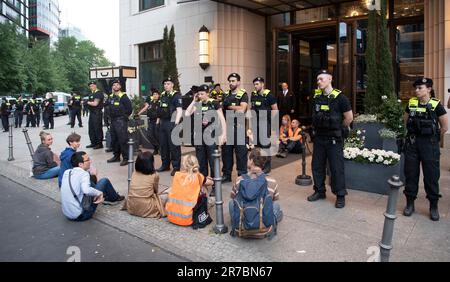 Berlin, Deutschland. 14. Juni 2023. Polizeibeamte stehen zwischen Aktivisten am Haupteingang des 'Ritz Carlton' Hotels am Potsdamer Platz. Mitglieder der Klimagruppe Last Generation saßen vor dem Haupteingang des Ritz-Carlton Hotels und einige friedlich aufgestellte Banner. Kredit: Paul Zinken/dpa/Alamy Live News Stockfoto