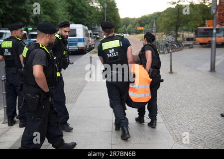 Berlin, Deutschland. 14. Juni 2023. Polizeibeamte bringen einen Aktivisten mit, um den Haupteingang zum 'Ritz Carlton' Hotel am Potsdamer Platz zu räumen. Mitglieder der Klimagruppe Last Generation saßen vor dem Haupteingang des Ritz-Carlton Hotels und einige friedlich aufgestellte Banner. Kredit: Paul Zinken/dpa/Alamy Live News Stockfoto