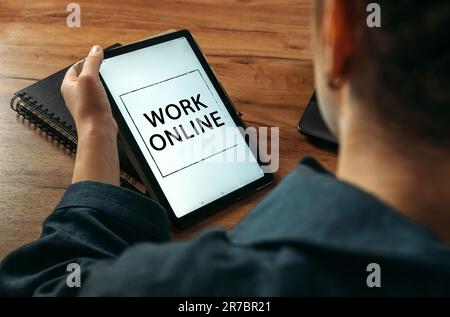 Geschäftskonzept. Eine Frau hält ein Tablet in der Hand auf dem Bildschirm, auf dem es geschrieben ist – Work Online Stockfoto