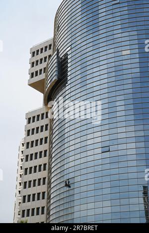 Fensterreiniger an der Fassade eines riesigen Wolkenkratzers Stockfoto