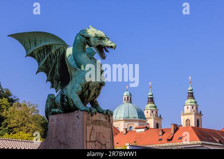 Die grüne Statue der Drachenbrücke von ljubljana und die grünen Kuppeln der St. nicholas Kathedrale Stockfoto