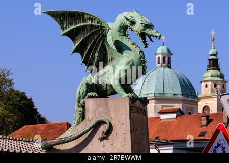 Die grüne Statue der Drachenbrücke von ljubljana und die grünen Kuppeln der St. nicholas Kathedrale Stockfoto