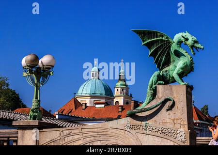 Die grüne Statue der Drachenbrücke von ljubljana und die grünen Kuppeln der St. nicholas Kathedrale Stockfoto