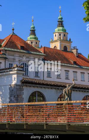 Hunderte von roten Liebesschlössern hängen an den Seiten der Metzgerbrücke mit ihren Bronzeskulpturen, die den Ijubljianica Rive zum zentralen Markt überqueren Stockfoto