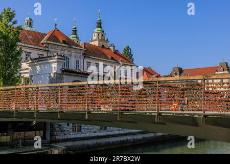 Hunderte von roten Liebesschlössern hängen an den Seiten der Metzgerbrücke mit ihren Bronzeskulpturen, die den Ijubljianica Rive zum zentralen Markt überqueren Stockfoto