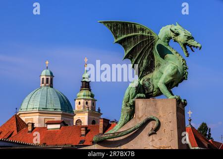 Die grüne Statue der Drachenbrücke von ljubljana und die grünen Kuppeln der St. nicholas Kathedrale Stockfoto