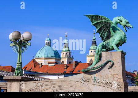 Die grüne Statue der Drachenbrücke von ljubljana und die grünen Kuppeln der St. nicholas Kathedrale Stockfoto