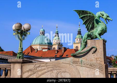 Die grüne Statue der Drachenbrücke von ljubljana und die grünen Kuppeln der St. nicholas Kathedrale Stockfoto