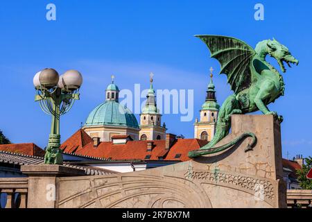 Die grüne Statue der Drachenbrücke von ljubljana und die grünen Kuppeln der St. nicholas Kathedrale Stockfoto