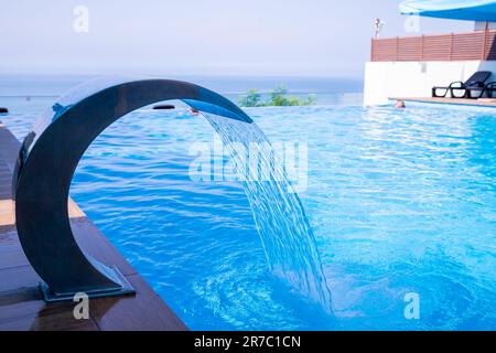 Leeren Swimmingpool mit Wasserfall Jet und Jacuzzi in Aktion Stockfoto