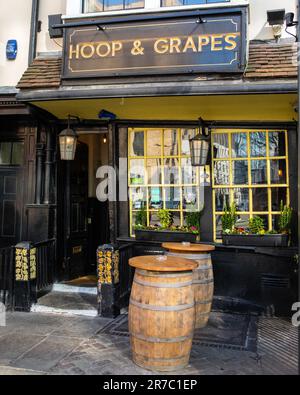 London, Großbritannien - März 2. 2023: Das historische öffentliche Haus Hoop and Grapes - ein denkmalgeschütztes Gebäude der Kategorie II in der Aldgate High Street in der City of London, Großbritannien. Stockfoto