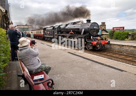 Die Dampflokomotive „The Sherwood Forester“ fährt durch den Bahnhof in Settle, North Yorkshire, mit einem Spezialzug nach Carlisle. Stockfoto