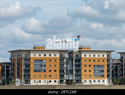 Woolwich, London - 15. Mai 2023: Luxair-Flugzeug fliegt tief über den Apartmentblock und landet am City Airport Stockfoto