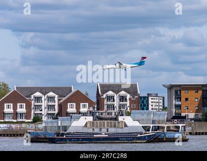Woolwich, London - 15. Mai 2023: Luxair-Flugzeug fliegt tief über den Apartmentblock und landet am City Airport Stockfoto