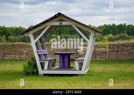 Holzpavillon im grünen Park. Reisen und Entspannen in den Wäldern. Ruheplatz mit Grillbereich. Stockfoto