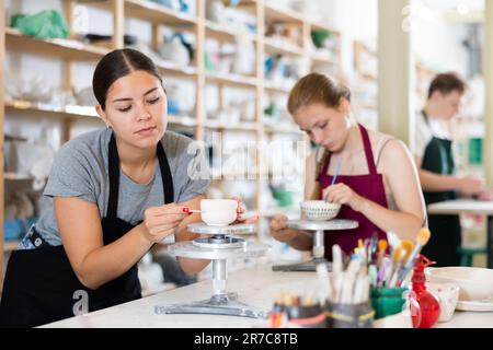 Junge Lehrerin, die Keramikbecher macht Stockfoto