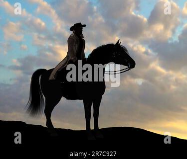 Cowboy Klaus Silhouette - Ein Cowboy und sein Pferd stehen auf einer Klippe und ruhen sich während des Sonnenuntergangs aus. Stockfoto