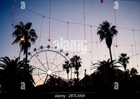 Sonnenuntergang im Hafen von Barcelona, mit Riesenrad im Hintergrund. Stockfoto