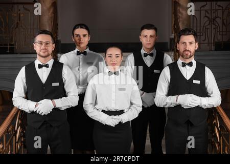Gruppe von Trainees, die formelle Kleidung im Hotel tragen. Professionelle Butler-Kurse Stockfotografie
