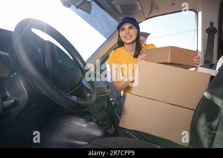 Der Kurier nimmt das Paket vom Auto ab. Lieferservice Stockfoto