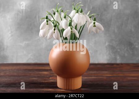 Wunderschöne Schneetropfen in Vase auf Holztisch Stockfoto