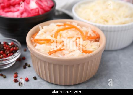 Köstliches Sauerkraut, nach verschiedenen Rezepten auf einem hellgrauen Tisch zubereitet, Nahaufnahme Stockfoto