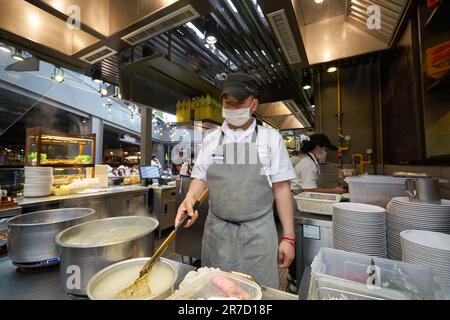 BANGKOK, THAILAND - CIRCA JANUAR 2020: Kochen von Männern im Food Court im Einkaufszentrum Siam Center. Stockfoto