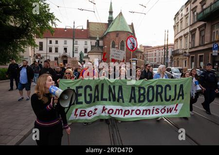 Demonstranten haben ein Banner und Symbole für Frauenstreiks: Schwarze Regenschirme, Blitze und Kleiderbügel während der Demonstration gegen das restriktive Abtreibungsgesetz in Polen. Proteste im ganzen Land kommen nach Dorota Laliks Tod im Alter von 33 war sie schwanger und starb am 24. Mai 2023 im John Paul II Krankenhaus in Nowy Targ, Südpolen. Polen verfügt über eines der restriktivsten europäischen Abtreibungsgesetze. Die Demonstranten gingen vom Hauptmarktplatz durch die Straßen von Krakau zum Frauenrechtsplatz in der Nähe des Büros der regierenden rechtsextremen Partei PiS (Recht und Gerechtigkeit) und neben dem Pap Stockfoto