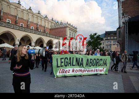 Demonstranten haben ein Banner und Symbole für Frauenstreiks: Schwarze Regenschirme, Blitze und Kleiderbügel während der Demonstration gegen das restriktive Abtreibungsgesetz in Polen. Proteste im ganzen Land kommen nach Dorota Laliks Tod im Alter von 33 war sie schwanger und starb am 24. Mai 2023 im John Paul II Krankenhaus in Nowy Targ, Südpolen. Polen verfügt über eines der restriktivsten europäischen Abtreibungsgesetze. Die Demonstranten gingen vom Hauptmarktplatz durch die Straßen von Krakau zum Frauenrechtsplatz in der Nähe des Büros der regierenden rechtsextremen Partei PiS (Recht und Gerechtigkeit) und neben dem Pap Stockfoto