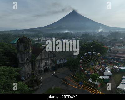 Camalig, Philippinen. 14. Juni 2023. Rauch aus Mt. Vulkan Mayon am frühen Morgen des 14. Juni 2023, wie auf der alten Kirche Camalig, Albay, Philippinen zu sehen. Das Pinangat-Festival von Camalig wurde aufgrund des Mt. Mayon-Ausbruch. (Foto von Sherbien Dacalanio/Pacific Press) Kredit: Pacific Press Media Production Corp./Alamy Live News Stockfoto