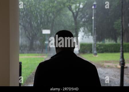 Rom, Italien. 14. Juni 2023. Im Casa del Cinema in Rom (Foto von Matteo Nardone/Pacific Press/Sipa USA) wartet ein Mann darauf, dass der Regen zu Ende geht. SIPA USA/Alamy Live News Stockfoto