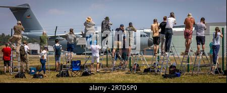 Wunstorf, Deutschland. 12. Juni 2023. Flugzeugbeobachter stehen an einem Zaun vor dem Luftwaffenstützpunkt Wunstorf und fotografieren einen Airbus A400M der Deutschen Luftwaffe. Vom 12. Bis 23. Juni nehmen 25 Nationen und 10.000 Soldaten mit 250 Flugzeugen unter deutscher Führung am Air Force Manöver „Air Defender 2023“ Teil. Kredit: Moritz Frankenberg/dpa/Alamy Live News Stockfoto