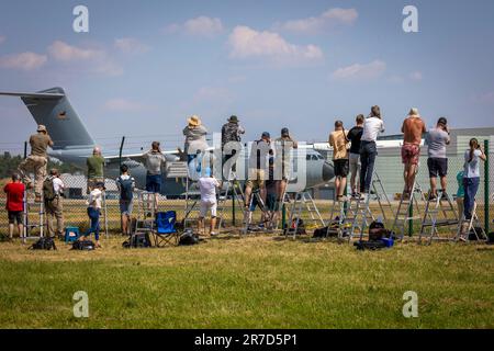 Wunstorf, Deutschland. 12. Juni 2023. Flugzeugbeobachter stehen an einem Zaun vor dem Luftwaffenstützpunkt Wunstorf und fotografieren einen Airbus A400M der Deutschen Luftwaffe. Vom 12. Bis 23. Juni nehmen 25 Nationen und 10.000 Soldaten mit 250 Flugzeugen unter deutscher Führung am Air Force Manöver „Air Defender 2023“ Teil. Kredit: Moritz Frankenberg/dpa/Alamy Live News Stockfoto