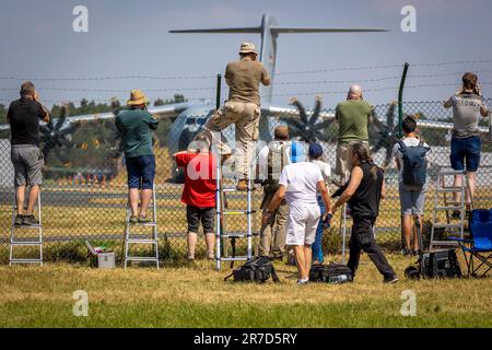 Wunstorf, Deutschland. 12. Juni 2023. Flugzeugbeobachter stehen an einem Zaun vor dem Luftwaffenstützpunkt Wunstorf und fotografieren einen Airbus A400M der Deutschen Luftwaffe. Vom 12. Bis 23. Juni nehmen 25 Nationen und 10.000 Soldaten mit 250 Flugzeugen unter deutscher Führung am Air Force Manöver „Air Defender 2023“ Teil. Kredit: Moritz Frankenberg/dpa/Alamy Live News Stockfoto