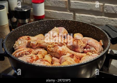 Hühnerschenkel in der Pfanne auf einem Gasherd gebraten. Stockfoto
