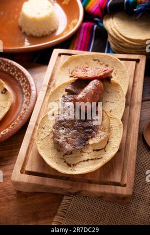 Im Taco-Campechano-Stil, Carne Asada. (Bratfleisch) und Chorizo oder Longaniza, sehr beliebtes Gericht in Nordmexiko, auch Asado, Discada oder Parrill genannt Stockfoto