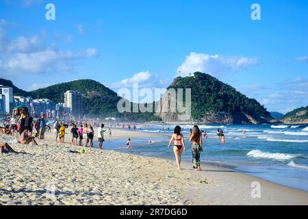 Rio de Janeiro, Brasilien - 25. Mai 2023: Menschen versammeln sich am Copacabana-Strand und nehmen an verschiedenen Aktivitäten am Sandstrand Teil, während sie vom oc umgeben sind Stockfoto
