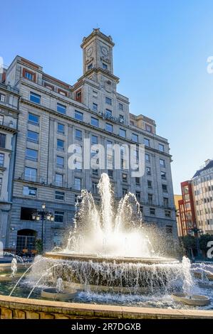 Oviedo, Spanien - 12. Februar 2023: Das Cajastur Bank Building und ein Springbrunnen auf der Plaza de la Escandalera. Die Gegend ist ein lokales Wahrzeichen und ein Stockfoto