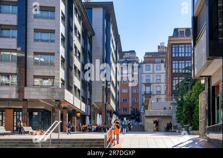 Oviedo, Spanien - 12. Februar 2023: Kinder und Erwachsene in einem Stadtgebiet, umgeben von Stadtgebäuden. Das Stadtbild zeigt eine lebhafte Innenstadt Stockfoto