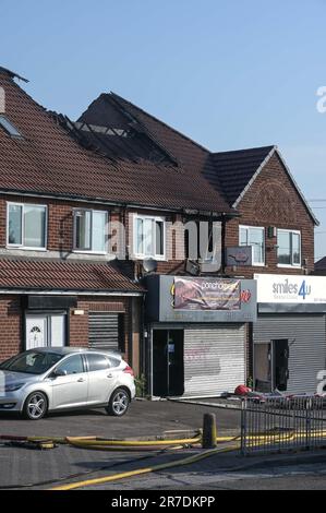 Lea Village Road, Birmingham 15. Juni 2023 - Fifty Firefighters sind am Schauplatz eines schweren Flachfeuers über der Desi Flame im Kitts Green-Gebiet von Birmingham. Das Inferno riss ein großes Loch im Dach und verursachte einen großen Schaden. Die Feuerwehrleute wurden um 3,56am Uhr in eine brennende Wohnung gerufen, von der West Midlands Polizei zur Lea Village Road. Mehrere Straßen wurden gesperrt und die Bewohner evakuiert, nachdem die Feuerwehr feststellte, dass der Brand in der Nähe mehrerer Gasleitungen lag, was eine Explosionsgefahr darstellte. Ein Sprecher der Feuerwehr von Staffordshire und West Midlands sagte: "Wir wurden ursprünglich von der Polizei zu einer Wohnung gerufen Stockfoto