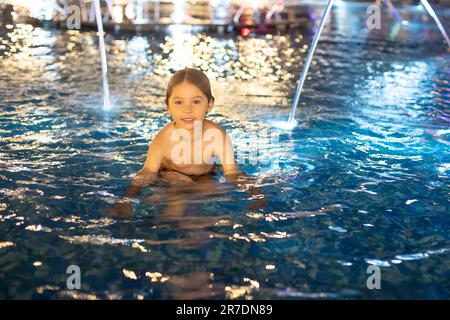 Süßes Kind, Junge, spielt mit Wasser im Brunnen in Tel Aviv, Lichter und Farben Stockfoto