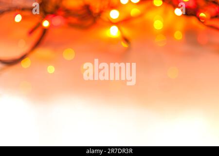 Bokeh-Hintergrund. Unschärfe-Kerzen. Bokeh-Licht, schimmernde, verschwommene gelbe Lichter auf Rot. Abstrakter, verschwommener weihnachtshintergrund. Stockfoto